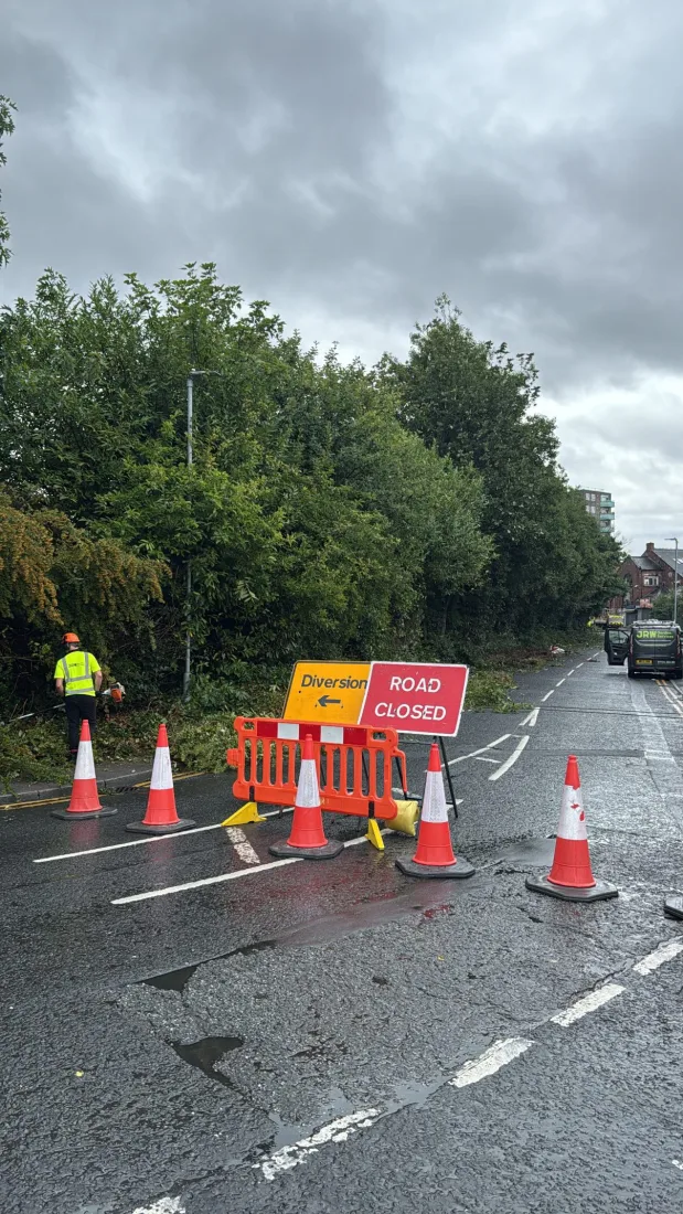 JRW Garden Services operative managing traffic control, with road closed signage and cones in place on a commercial site